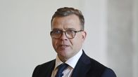 Puolilähikuvassa pukuun pukeutunut Petteri Orpo katsoo ohi kamerasta.