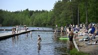 Ihmisiä Kuusijärven uimarannalla. Vasemmalla näkyy ponttoonilaituri.