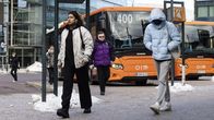Ihmisiä HSL:n bussin numero 400 edessä bussipysäkillä.