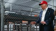 Donald Trump framför en cell med sängar i.