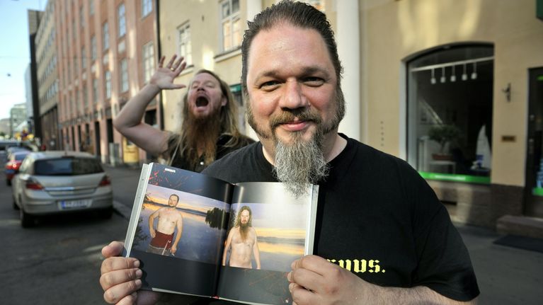 Mies pitelee kirjaa, jossa on kuvia Jouni Hynysestä. 
