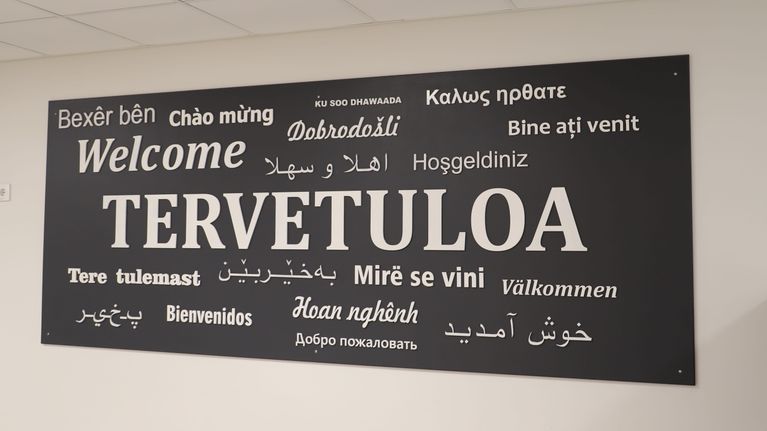En skylt där ordet välkommen står på många olika språk.