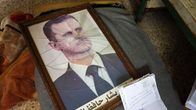 En inramad bild på Bashar al-Assad men söndrigt glas.