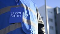 Anonyymi lakkovahti rakennuksen edessä.