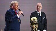 Donald Trump puhuu mikkiin Gianni Infantino vieressään. Edessä on kultainen pokaali, jossa kädet tavoittelevat palloa.