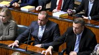  Mikko Polvinen ja Mikko Lunden painavat äänestysnappia eduskunnan istuntosalissa.