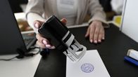 Vaalivirkailija leimaa korttia ennakkoäänestyksen yhteydessä.