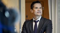 Mika Aaltola seisoi tummassa puvussa ja kädet ristissä kameroiden edessä.
