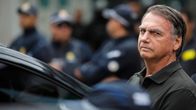 Bolsonaro katsoo kameraan auton vieressä.