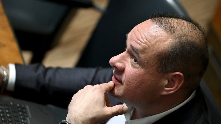 Mikko Polvinen istuu eduskunnan istuntosalissa.