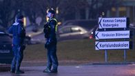 Poliisit keskustelevat illalla kadulla ja taustalla näkyy kylttejä