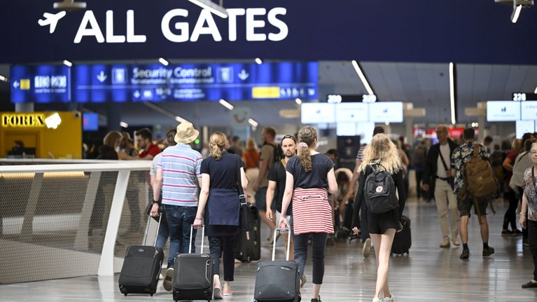 Passagerare på väg mot sin gate på en flygplats.