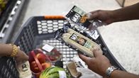 Asiakas tutkii kasvismakkara- ja kasvisleikepaketteja kaupassa.