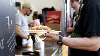 Asiakas pitelee ruoka-annostafestivaalin ruokakojulla.