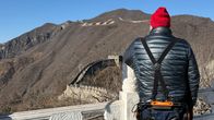 Turisti seisoo Kiinan muurilla yllään exoskeleton ei ulkoinen tukiranka.