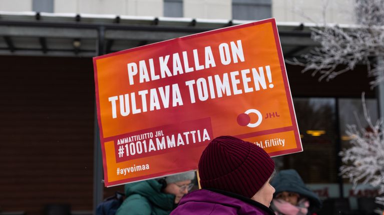 Lakkovahteja kylttien kanssa talvisella pihamaalla.