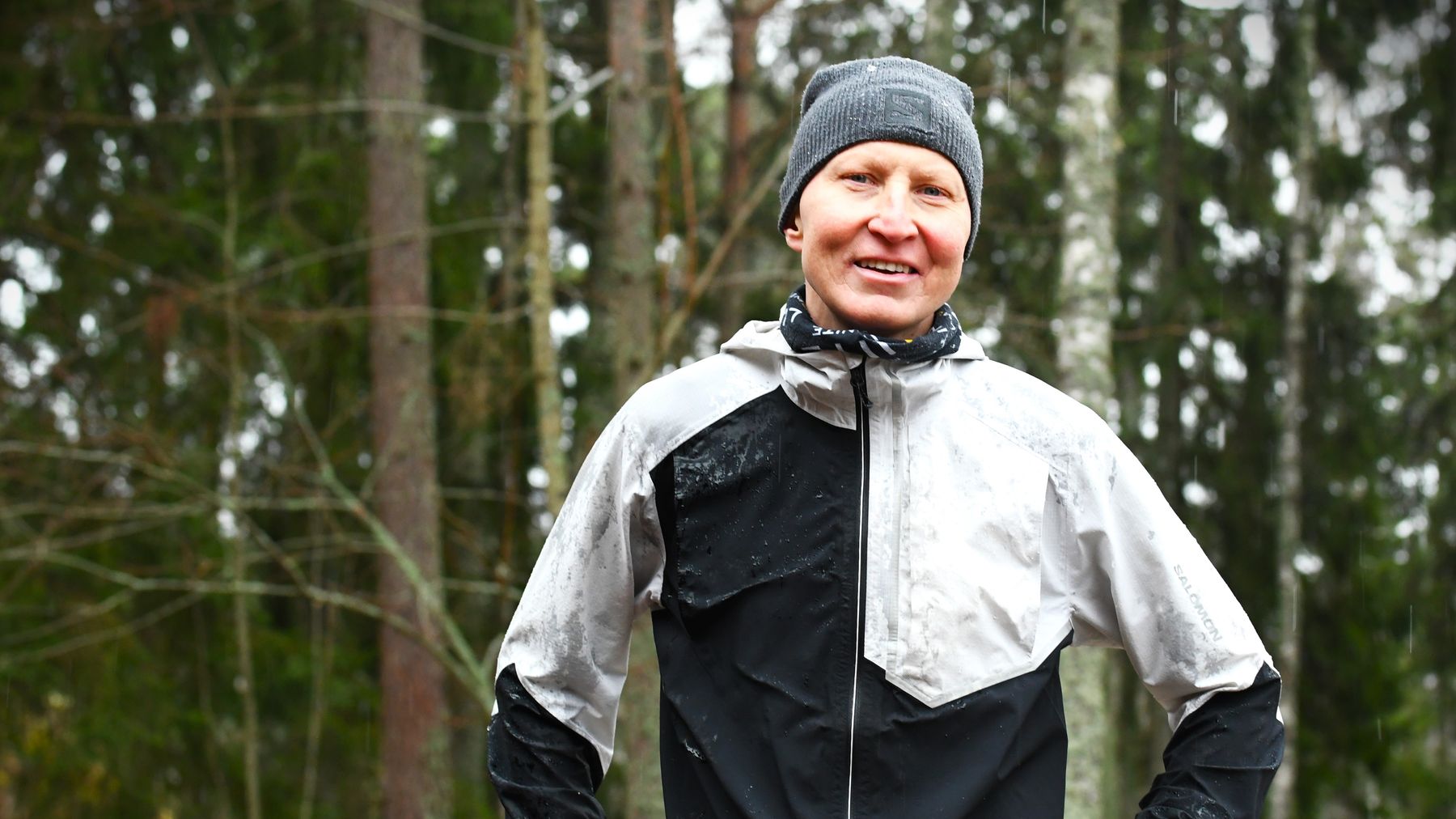 Orienteraren Mårten Boström i löpkläder i regnig skog. Tittar in i kameran och ser glad ut.