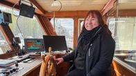 Laivuri Piia Kinnunen istuu laivan ohjaamossa ruorin ääressä.