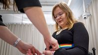 Tutkija kiinnittää mittalaitteita koehenkilön käteen laboratoriossa fysiologisia mittauksia varten.
