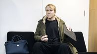 Aleksanteri Kivimäki odottaa vuoroaan käräjäoikeuden istuntosalin ulkopuolella.