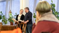 Johanna Virsunen ja Olli Halttu harjoittelevat menuteatterin esitystä. Näyttelijät hymyilevät toisilleen.