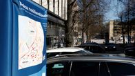 Hupulla peitetty pysäköintimaksupääte ja autoja parkissa.