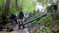 Människor bygger grusbäddar i en å så att öringen kan leka där. 