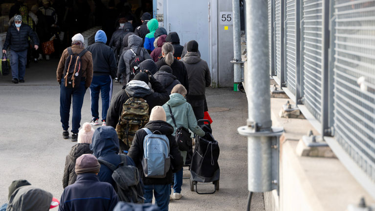 Photo shows a breadline in Helsinki.