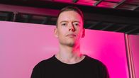 Toimittaja Anton Vanha-Majamaa vaaleanpunaista taustaa vasten.
