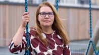 Miia Kemppi istuu keinussa ruskea-valkoisessa paidassa.