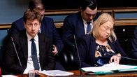 Ministrar i regeringsbåset i riksdagen. Längst till vänster en mörkblond man i mörk kostym, bredvid honom en blond kvinna.