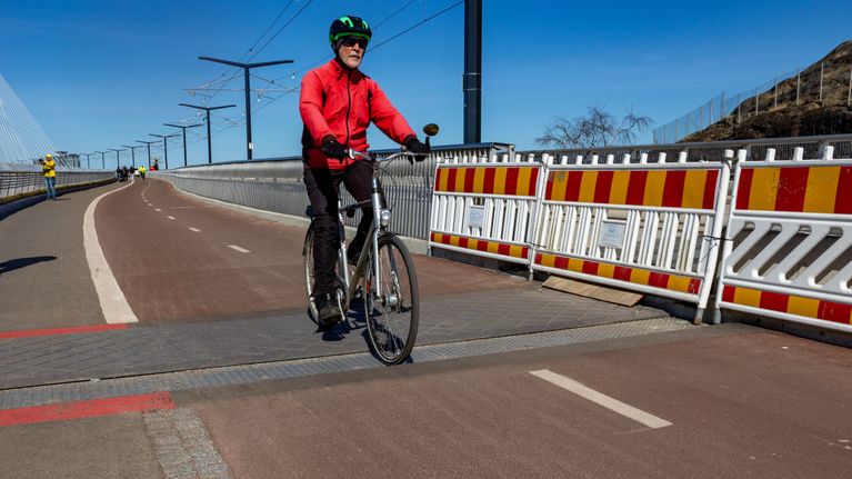 Person riding a bike on a long bridge.