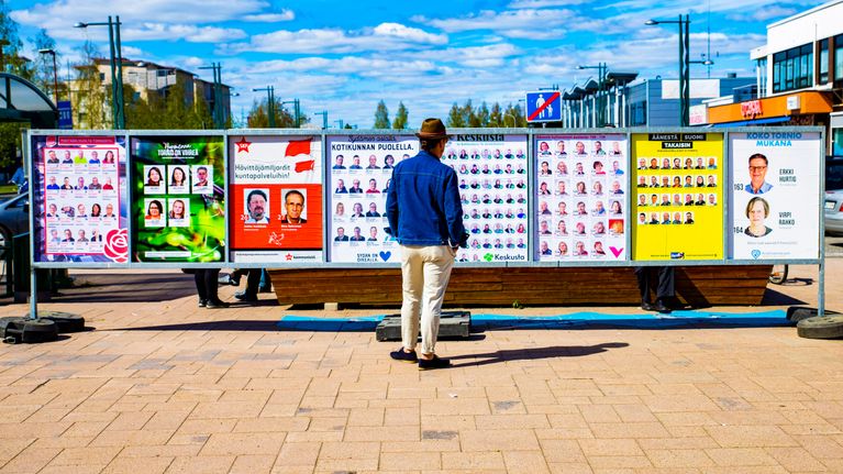 Mies katselee kuntavaalien mainoksia Torniossa.