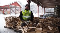 Halkokauppias Kalle Nisonen seisoo halkolavojen vieressä.