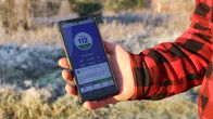 Käsi ojentaa puhelinta, jossa näkyy 112 Suomi -sovellus.