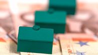 Monopoly houses sitting on cash.