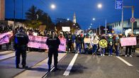 Poliisit ja Elokapinan mielenosoittajat ovat vastakkain Eduskuntatalon edessä iltapimeällä.