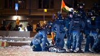 Siviili makaa maassa poliisien ympäröimänä.