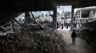 Lapsi kävelee osittain raunioituneen rakennuksen sisällä Gazan Khan Yunisissa 27. toukokuuta 2026.