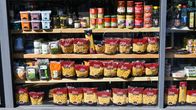En hylla i en butik med livsmedel som pasta och konservburkar.