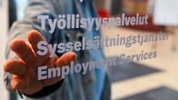 Photo shows a person at the door of an employment services office.