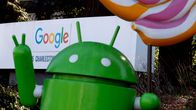 Googlen Android-hahmo kuvattuna Google-logon edessä.