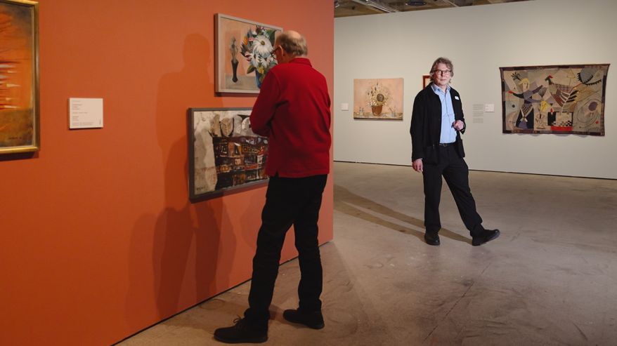 Museovalvoja Pekka ilmestyy kulman takaa, vieressä mies katsoo selin taideteosta.