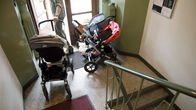 Strollers in an apartment building's stairway.
