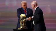 Donad Trump och Gianni Infantino skakar hand vid en stor gultrofé.