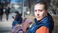 Tuuli Jääskeläinen istuu puistonpenkillä ja puhelin kädessä.