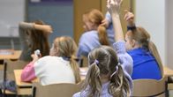 Photo shows children in a classroom.