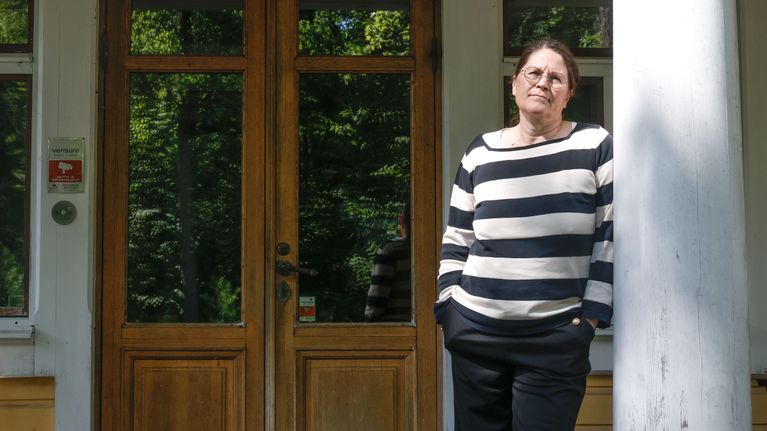 Koiskalan kartanon emäntä Pauliina Salo nojaa pylvääseen kartanon sisäänkäynnillä.