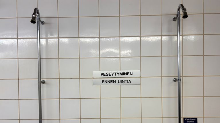 Kuusankosken uimahallin seinässä on kyltti jossa kehotetaan peseytymään. 