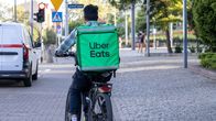 Uber Eats -lähetti ajaa polkupyörää.
